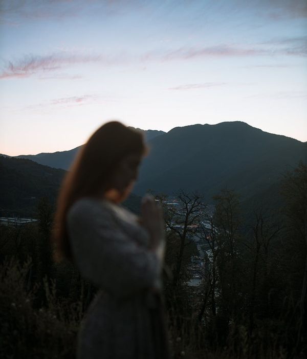Silhouette of a person meditating against a softly lit background.